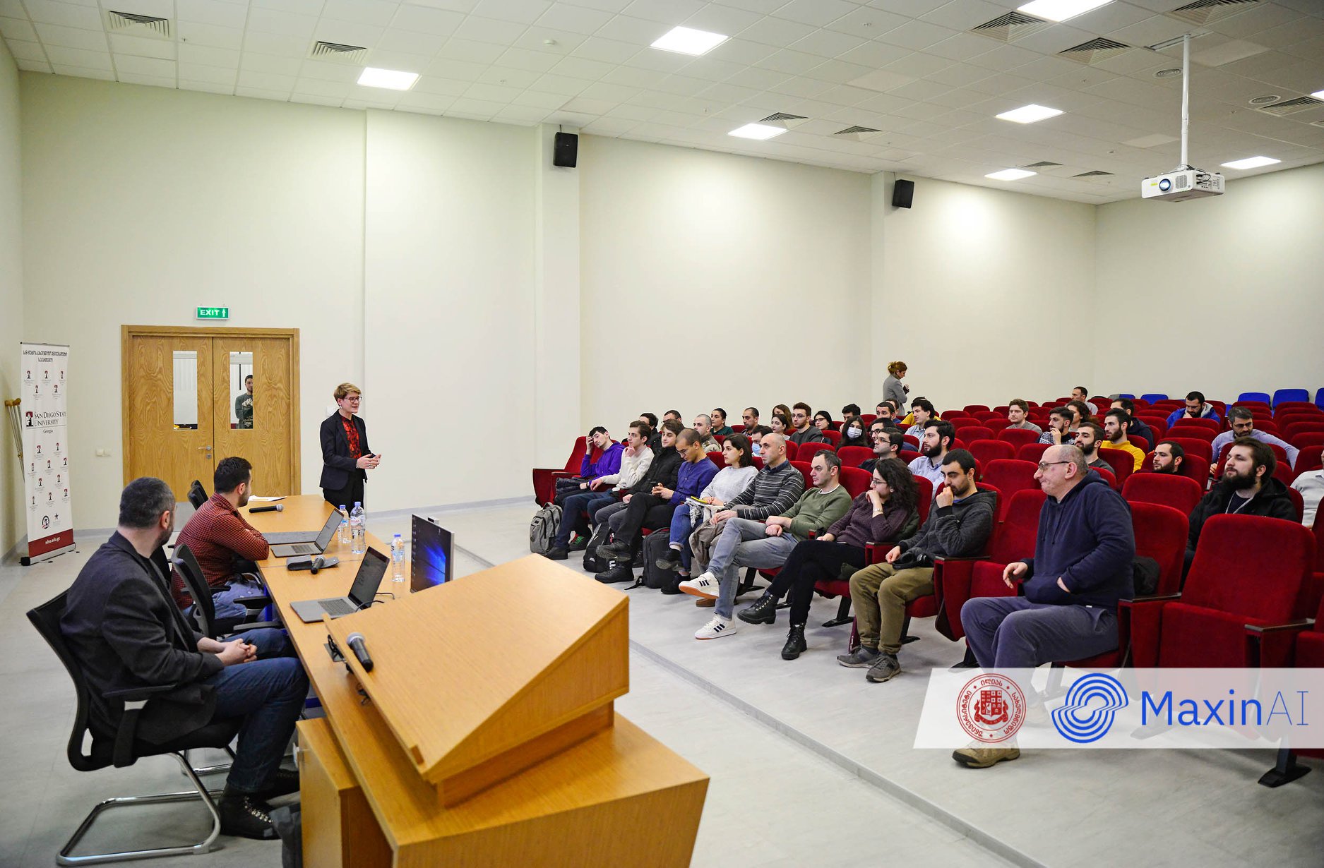 A School of AI lecture hall in Tbilisi, with students seated facing the speaker at the front of the room.